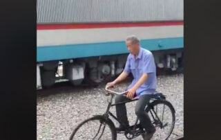 man balance bike riding on railroad track