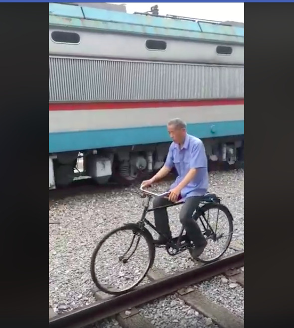 man balance bike riding on railroad track