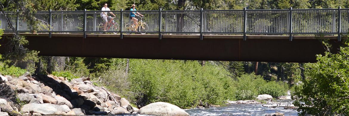 Bikers riding over a bridge on the Truckee River
